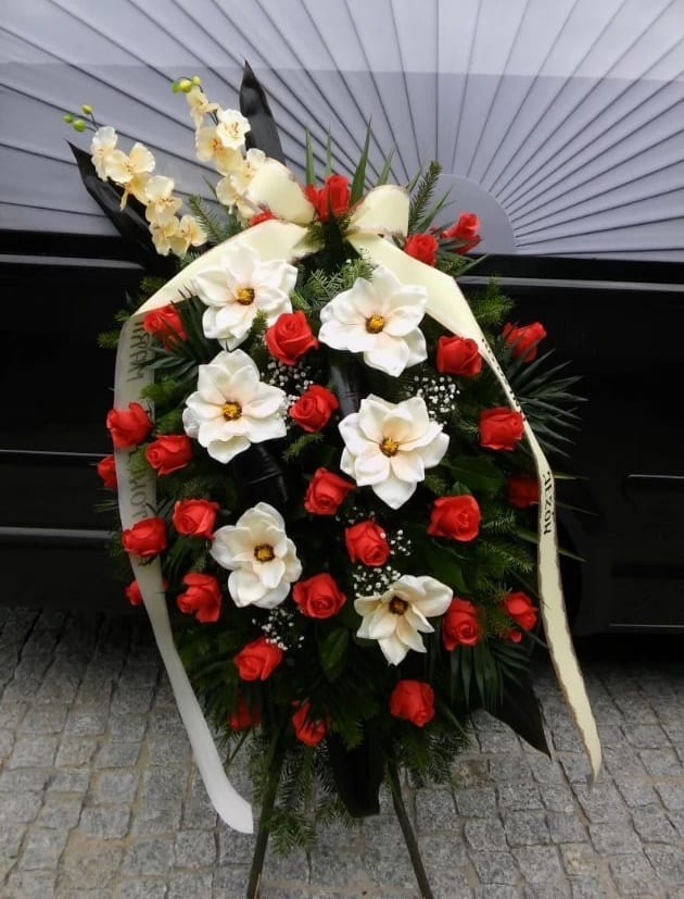 duży wieniec pogrzebowy z czerwonych róż i białych kwiatów