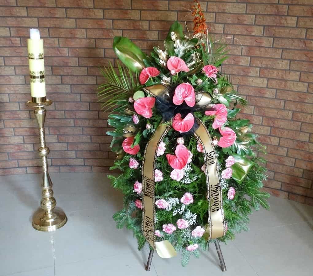 duży wieniec stojący z różowymi kwiatami w zakładzie pogrzebowym krawczyk