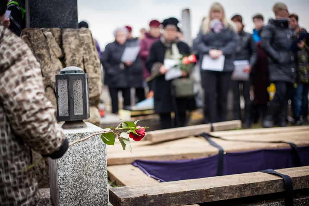 żałobnicy podczas ceremonii pogrzebowej na cmentarzu