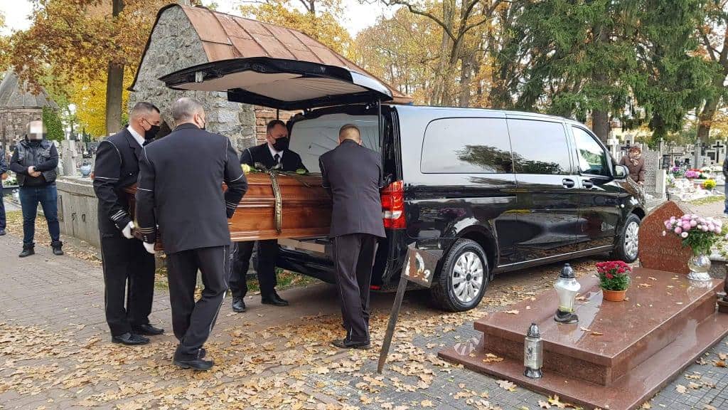 Zakład Pogrzebpwy Charon - pracownicy umieszczający trumnę w karawanie pogrzebowym